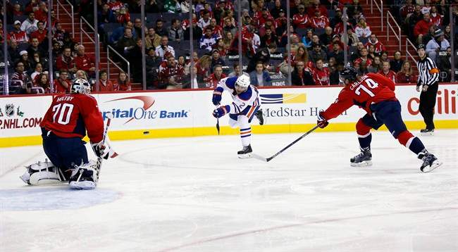 Edmonton Oilers right wing Nail Yakupov (10), from Russia, shoots the puck as Washington Capitals goalie Braden Holtby (70) is ready to block as Capitals defenseman John Carlson (74) defends, in the second period of an NHL hockey game, Monday, Nov. 23, 2015, in Washington.