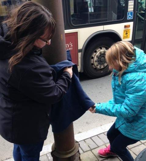 Zipping a coat around a pole that someone can come take later if they are cold.