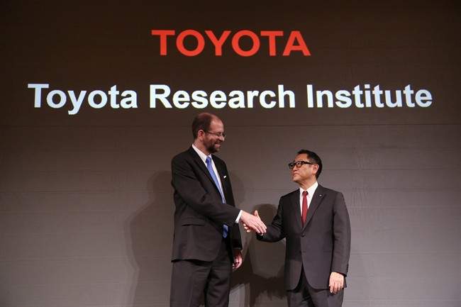 Toyota Motor Corp.'s Executive Technical Advisor Gill Pratt, left, and President Akio Toyoda, right, shake hands during a press conference on artificial intelligence in Tokyo, Friday, Nov. 6, 2015. Toyota is investing $1 billion in a research company it's setting up in Silicon Valley to develop artificial intelligence and robotics, underlining the Japanese automaker's determination to lead in futuristic cars that drive themselves and apply the technology to other areas of daily life. 