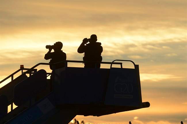 Security officials stand guard as they wait for the plane carrying US President Barack Obama to land in Antalya, Turkey, Sunday, Nov. 15 2015 for the G-20 summit. 