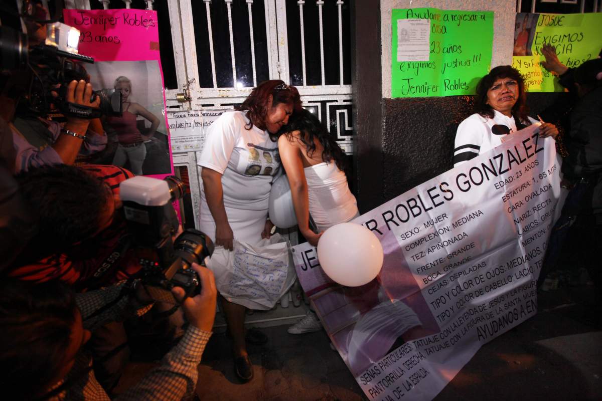 Friends and family protest, holding signs asking for justice for people abducted from a local bar, in Mexico City, Friday, July 26, 2013. 