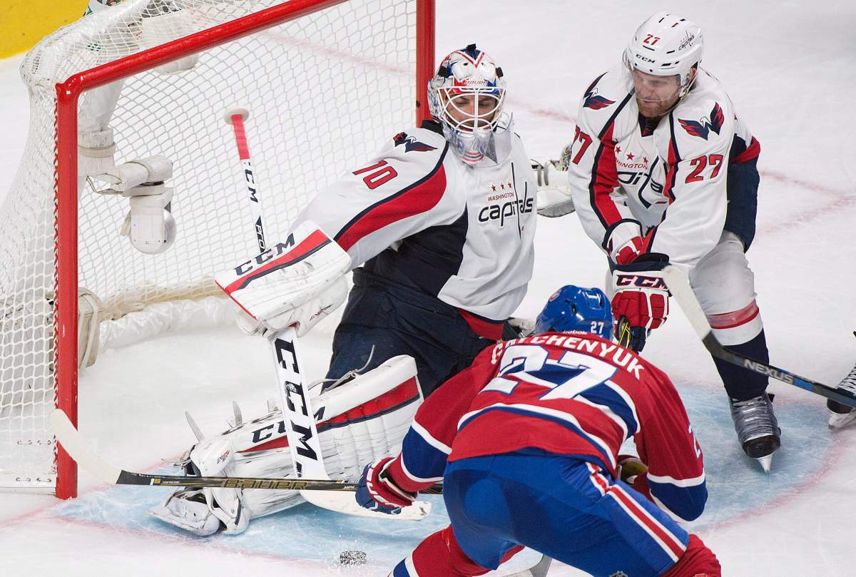 Washington Capitals goaltender Braden Holtby (70) makes a save against Montreal Canadiens' Alex Galchenyuk as Capitals' Karl Alzner defends during third period NHL hockey action in Montreal, Thursday, December 3, 2015. 
