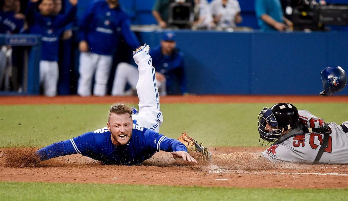 Toronto Blue Jays third baseman Josh Donaldson slides safe past Boston Red Sox catcher Blake Swihart at home plate during eighth inning AL baseball action at Rogers Centre in Toronto on Saturday, September 19, 2015.
