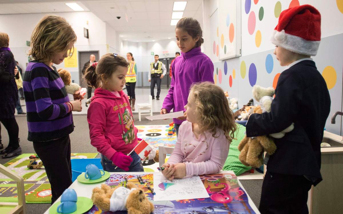 A Syrian refugee Salam (centre left) plays with The Canadian Governor General’s grandchildren (left) to right Georgina, Tea, Sadie and Lucas, as she arrives with her family at the Welcome Centre at Toronto’s Pearson Airport on Friday December 18, 2015.