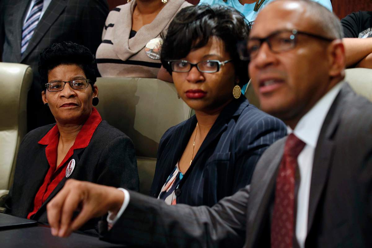 Geneva Reed-Veal, left, and Sharon Cooper, center, the mother and sister of Sandra Bland, listen to attorney Larry Rogers Jr., right, explain concerns about the Texas grand jury's role in the death of Naperville resident Sandra Bland, Monday, Dec. 21, 2015 in Chicago.