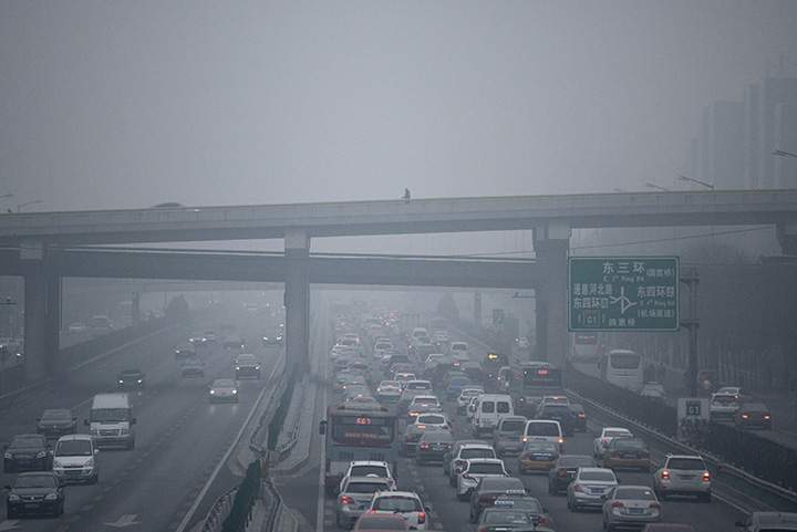 A man walks along an overpass amid heavy air pollution in Beijing on Dec. 8, 2015.