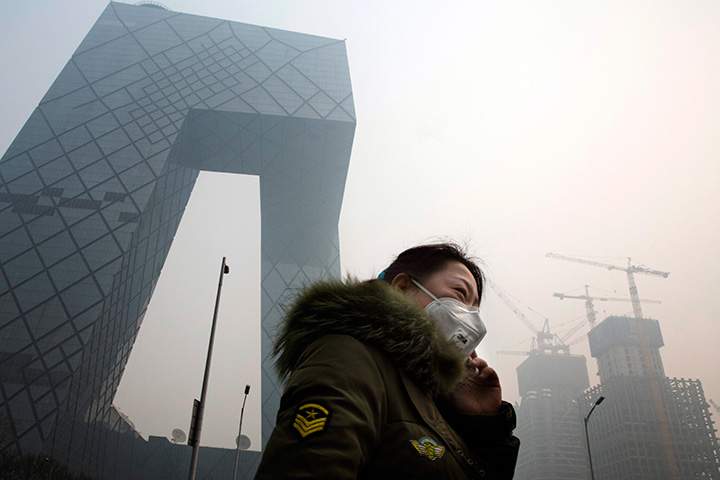 A woman wears a mask during a day of heavy pollution in Beijing, China on Wednesday, Dec. 9, 2015.