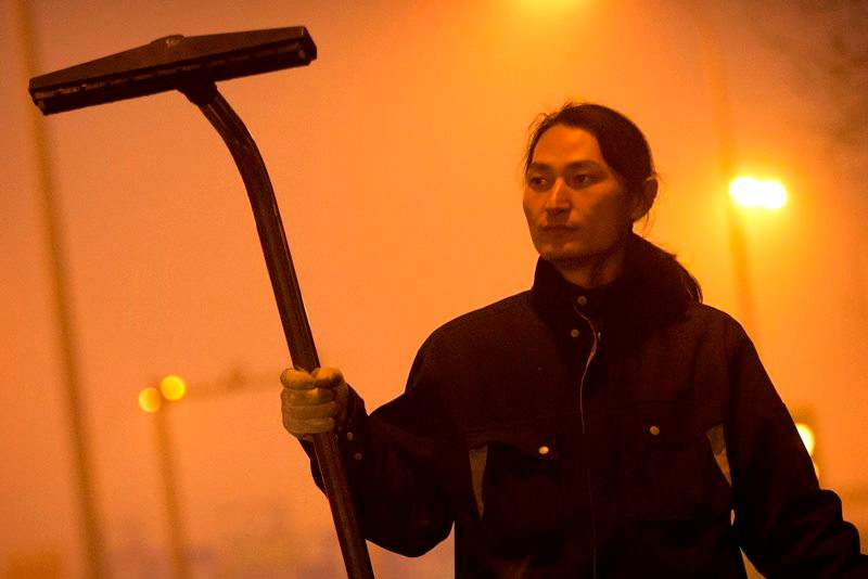 Chinese artist Wang Renzheng demonstrates the use of his industrial shop-vac alongside a highway in Beijing, Tuesday, Dec. 1, 2015. Wang spent 4 hours per day for 100 days vacuuming the Beijing air with an industrial shop-vac, then baked the accumulated dust and pollutants into a brick. 