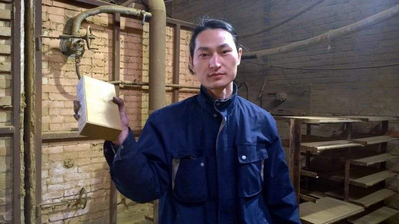 In this Monday, Nov. 30, 2015 photo, Chinese artist Wang Renzheng holds up a brick in Tangshan in northern China’s Hebei province containing dust and pollutants Wang vacuumed from theair in Beijing. 