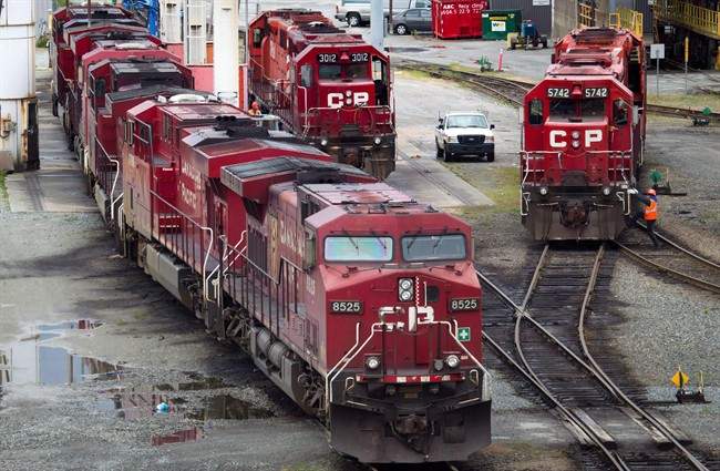 File Photo - A Canadian Pacific Rail maintenance worker climbs onto a locomotive at the company's Port Coquitlam yard east of Vancouver, B.C., on Wednesday May 23, 2012.
