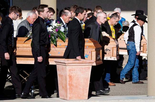 Pall bearers carry the three coffins of Catie Bott, who was 13, and her twin 11-year-old siblings, Jana and Dara Bott in Red Deer, Alta., Friday, Oct. 23, 2015.