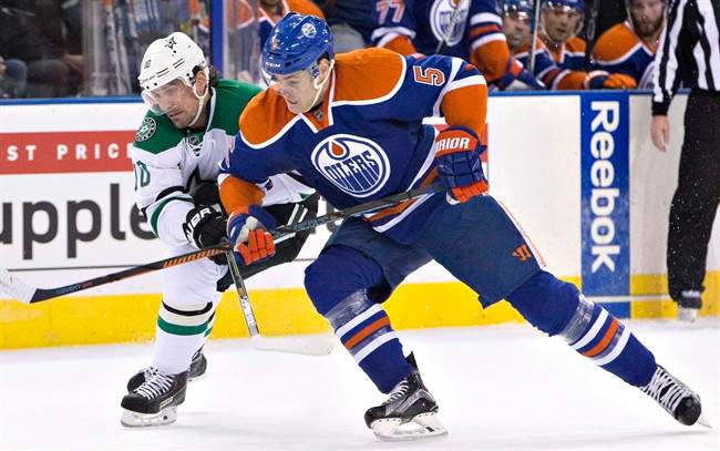 Dallas Stars' Patrick Sharp (18) and Edmonton Oilers' Mark Fayne (5) race for the puck during first period NHL action in Edmonton, Alta., on Friday December 4, 2015. The Oilers have placed Fayne on waivers.The defenceman would be sent to the American Hockey League's Bakersfield Condors if he clears.