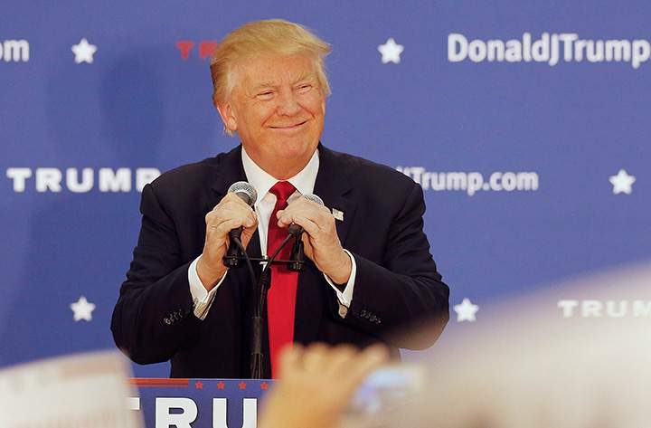 In this Dec. 1, 2015 file photo, Republican presidential candidate Donald Trump smiles as he arrives at a campaign stop at the White Mountain Athletic Club in Waterville Valley, N.H. 
