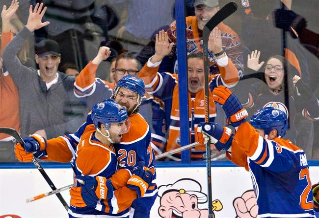 Edmonton Oilers' Jordan Eberle (14), Luke Gazdic (20) and Matt Hendricks (23) celebrate Eberle's goal against the Dallas Stars during overtime NHL action in Edmonton, Alta., on Friday December 4, 2015.