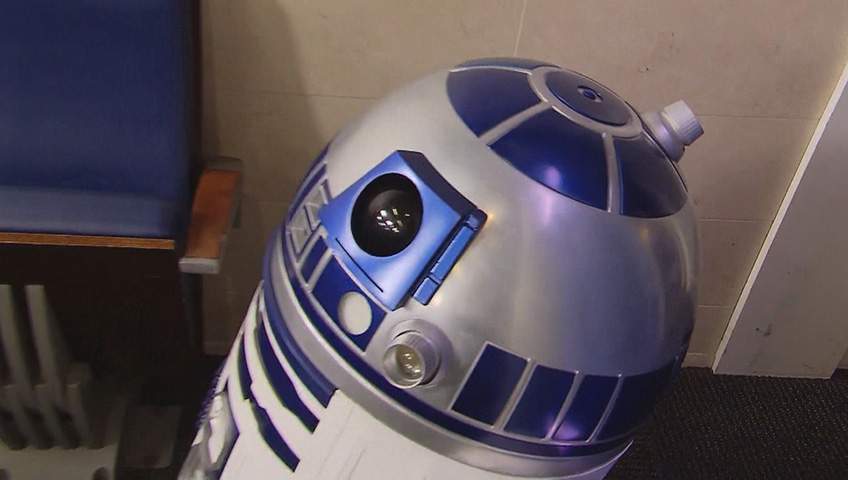 R2-D2 dazzles the press gathered at the briefing room in the White House