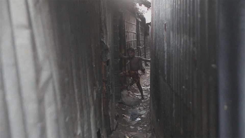 A climate-displaced boy takes shelter in a shantytown in Dhaka on October 18, 2015.