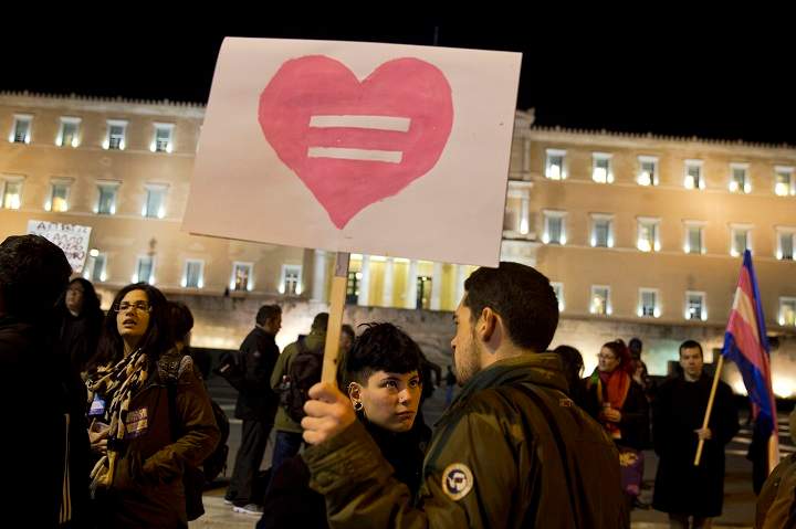 Gay rights supporters gather outside Greece's Parliament to voice approval of a civil partnership bill being debated by lawmakers, in central Athens, on Tuesday, Dec. 22, 2015.