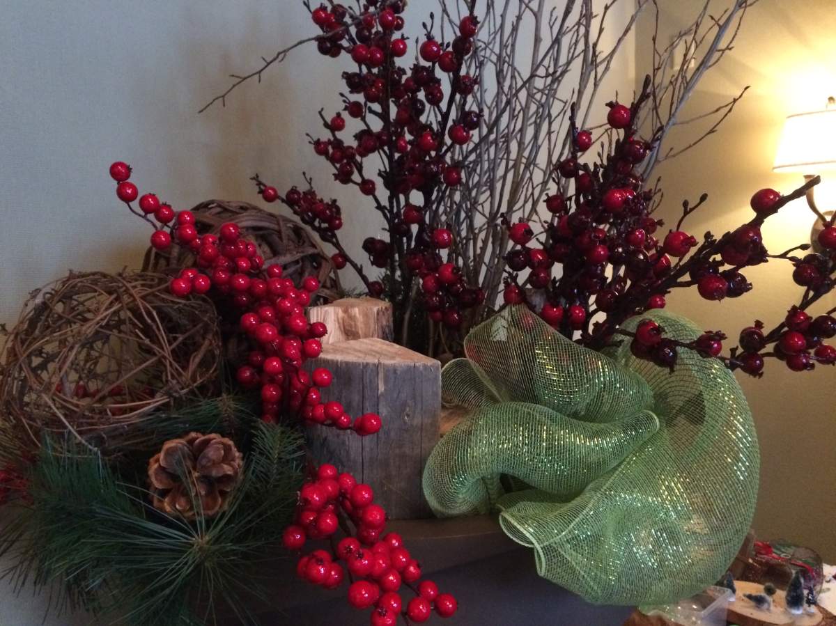 Stuff the bottom two-thirds of your planter with packing peanuts and fill the rest with logs, faux berries and branches. Finish off with a pop of green.