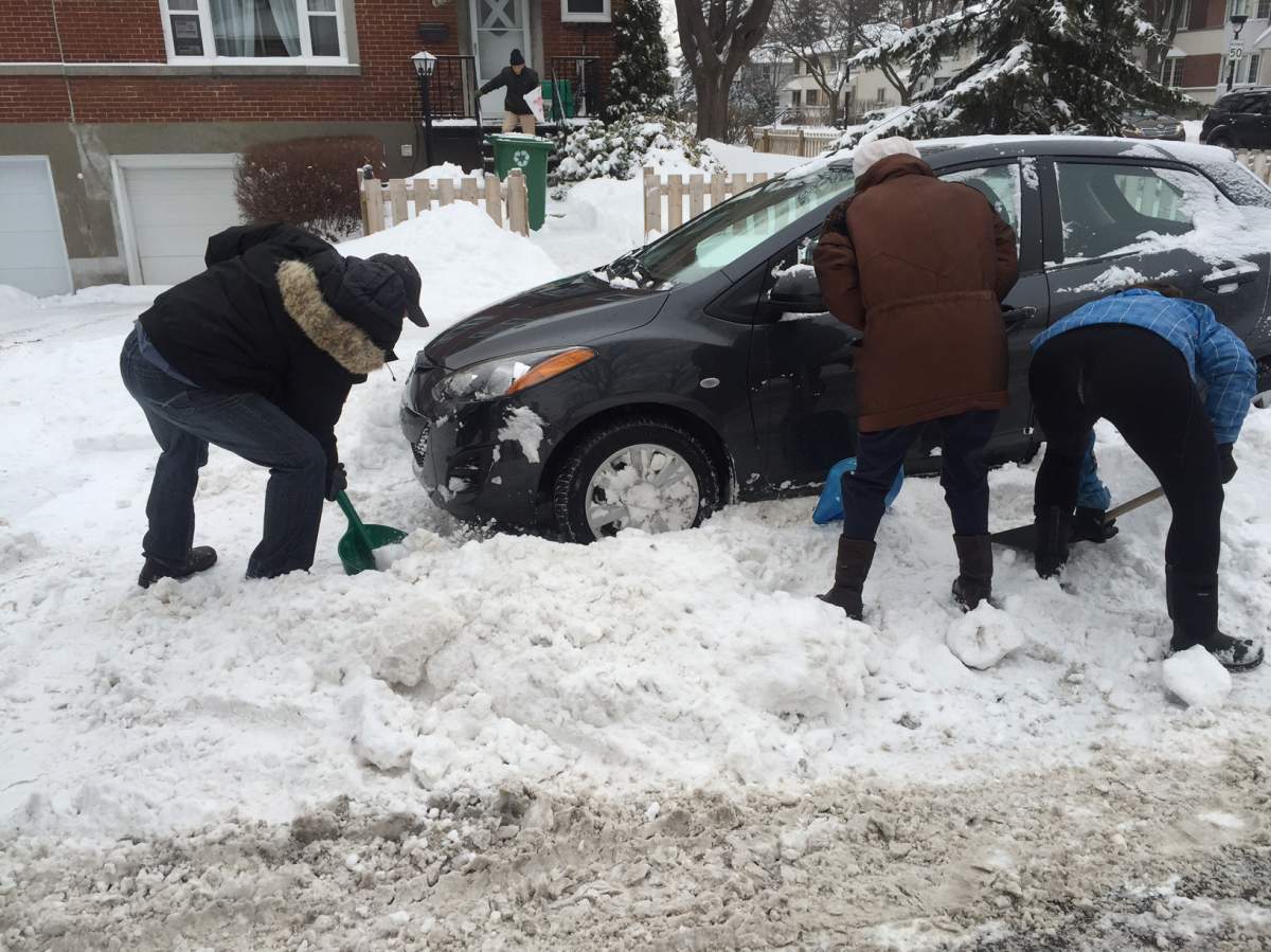 Mark Przybylowski and Paula Malolepszy help Nhu Le clear the snow around her car. Wednesday, Dec. 30, 2015.