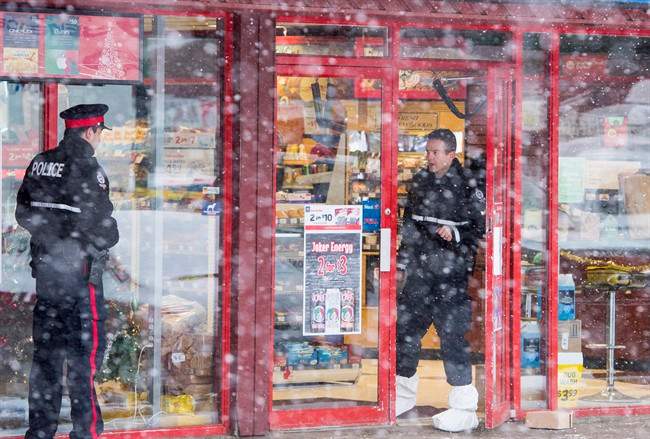 Homicide detectives investigate at a Mac's convenience store in Edmonton on Friday, December 18, 2015. A 13-year-old cried as he appeared briefly in youth court accused of killing two convenience store clerks.The boy, who cannot be identified, faces charges that include first-degree murder and robbery.THE CANADIAN PRESS/John Ulan.