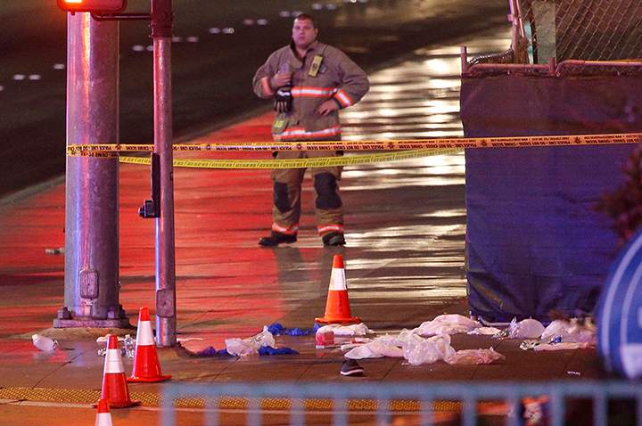Police and emergency crews respond to the scene after a car drove up onto a sidewalk along Las Vegas Boulevard, Sunday, Dec. 20, 2015, in Las Vegas. A woman intentionally swerved her car onto the busy sidewalk two or three times Sunday and mowed down people outside a Las Vegas casino.