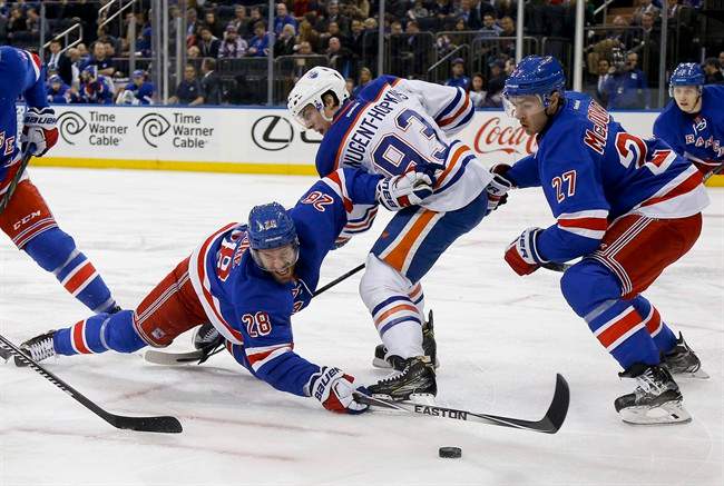 New York Rangers centre Dominic Moore (28) hits the ice as he reaches for the puck against Edmonton Oilers center Ryan Nugent-Hopkins (93) during a faceoff during the first period of an NHL hockey game, Tuesday, Dec. 15, 2015, in New York. (AP Photo/Julie Jacobson).