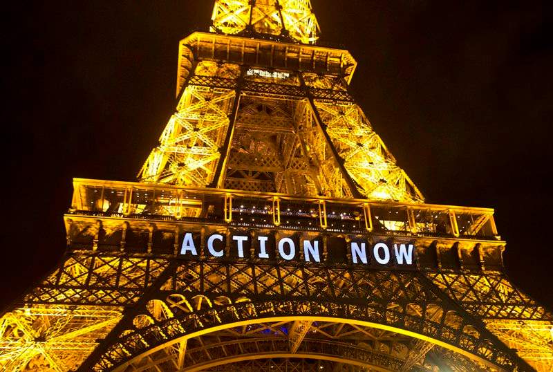 The Eiffel Tower lights up with the slogan"Action Now"referring to the COP21, United Nations Climate Change Conference in Paris, Sunday, Dec. 6, 2015. Negotiators adopted a draft climate agreement Saturday that was cluttered with brackets and competing options, leaving ministers with the job of untangling key sticking points in what is envisioned to become a lasting, universal pact to fight global warming. 