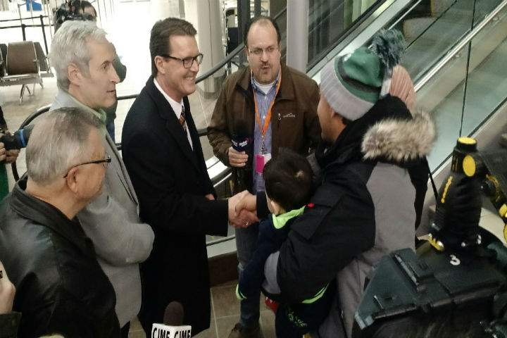 Saskatchewan Liberal MP Ralph Goodale, Mark Docerty (left), Sask Party MLA and Regina Mayor Mayor Michael Fougere greet Syrian refugees at the Regina International Airport on Dec. 21.