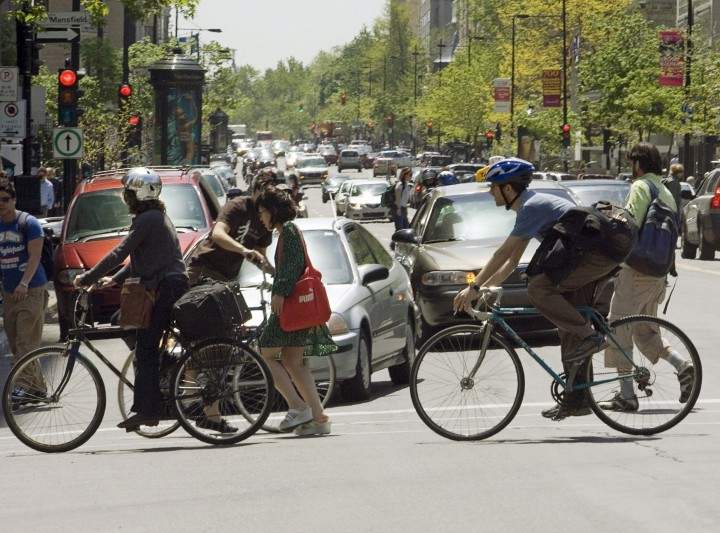 Pedestrians and cyclists cross Sherbrooke Street in downtown Montreal.