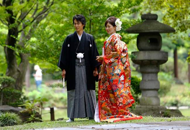 In this Aug. 12, 2015 file photo, a couple dressed in Japanese traditional wedding Kimonos pose for a wedding photograph at Hibiya park in Tokyo. Japan’s Supreme Court has ruled that requiring married couples to have the same surname is constitutional, dealing a blow to a longtime effort for gender equality in choosing names.