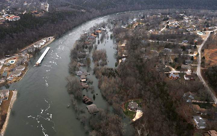In this Tuesday, Dec. 29, 2015 photo, rising waters of Lake Taneycomo flood several homes in Branson, Mo.