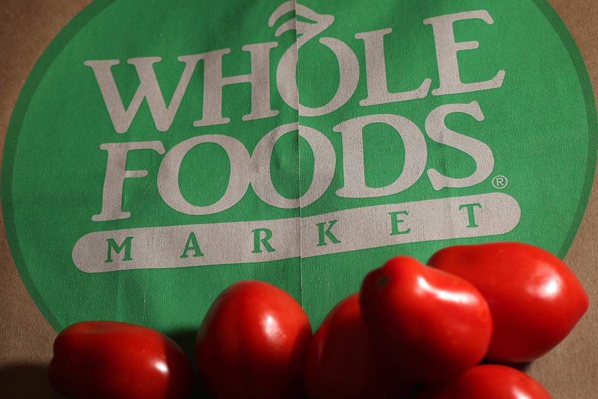 In this Monday, July 29, 2013, file photo, produce is placed on a Whole Foods paper bag in Andover, Mass. Grocery chain Whole Foods is cutting about 1,500 jobs, or 1.6 percent of its workforce, over the next eight weeks as it looks to lower prices and keep up with competition, the company announced Monday, Sept. 28, 2015.