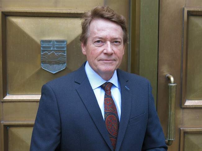 Former TV journalist Arthur Kent, who is suing PostMedia and columnist Don Martin for defamation, stops for a photo outside of the Calgary Courts Centre prior to the start of a four week defamation trial on Friday, Dec. 11, 2015. 