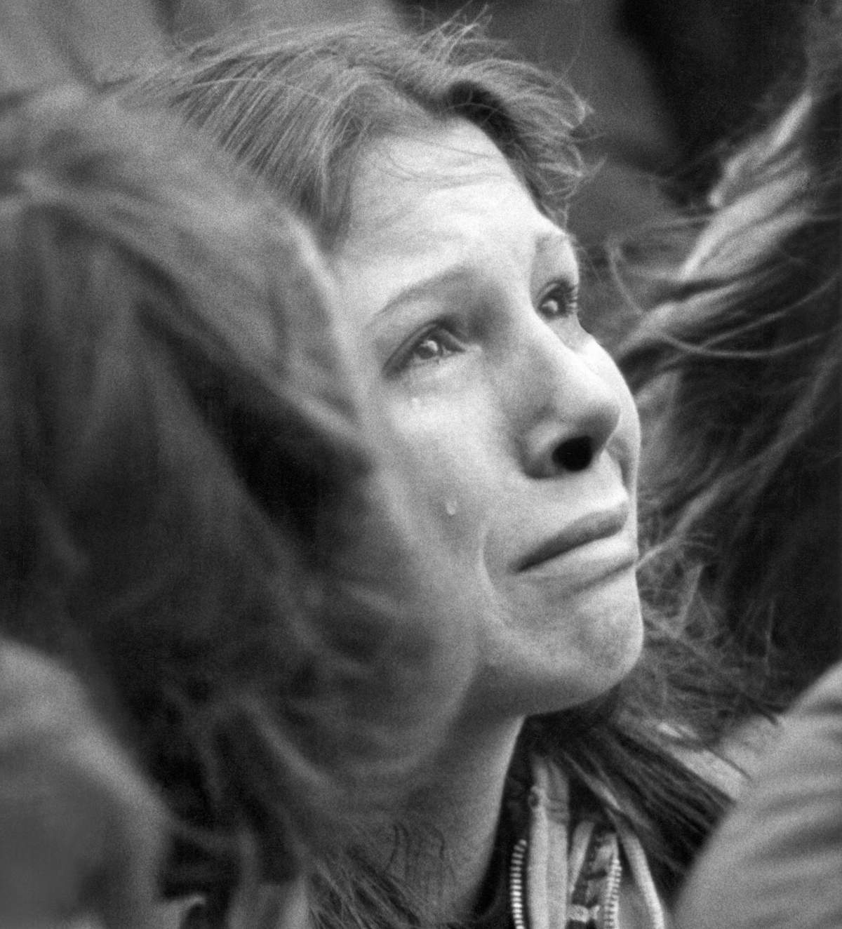 FILE – In this Dec. 14, 1980, file photo, a woman weeps during a ten minute silent vigil for John Lennon held in front of Trinity Church in Boston. An estimated crowd of 2,000 people came to honor the former Beatle who was murdered in New York. Thirty-five years ago on Dec. 8, Mark David Chapman shot and killed Lennon, a former Beatles member. (AP Photo/John Martell, File)