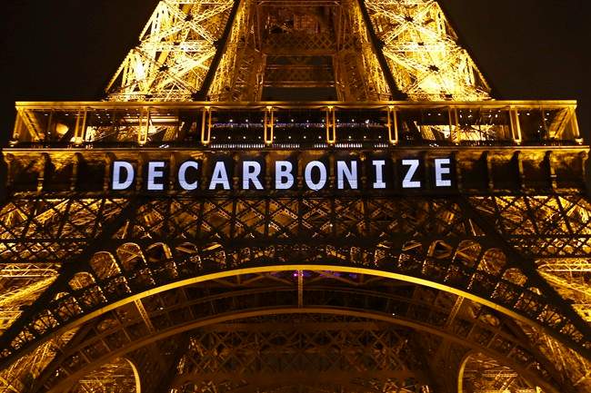 The slogan "DECARBONIZE" is projected on the Eiffel Tower as part of the COP21, United Nations Climate Change Conference in Paris, France, Friday, Dec. 11, 2015. 