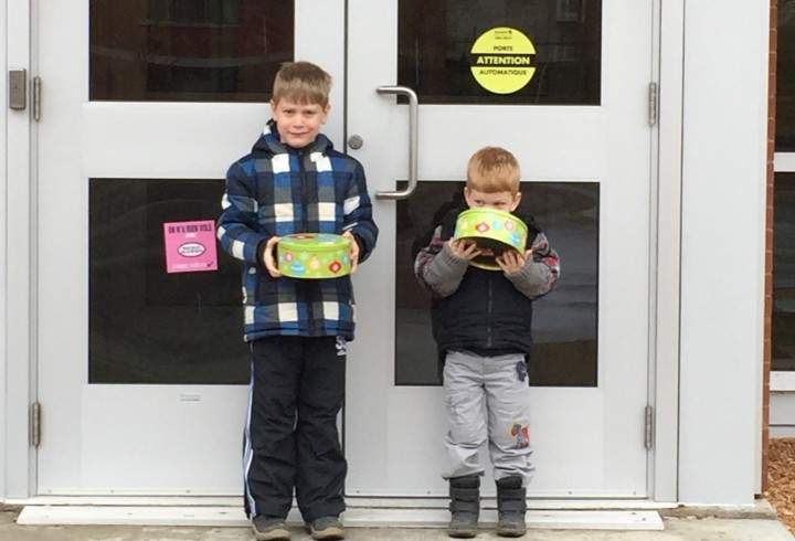 Kyle Mericx, 6 and Lucas Mericx, 3, stand outside their local police station with boxes of cookies.