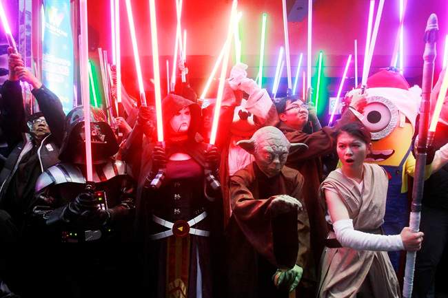 Fans dressed as Star Wars characters parade outside a movie theater showing "Star Wars: The Force Awakens".