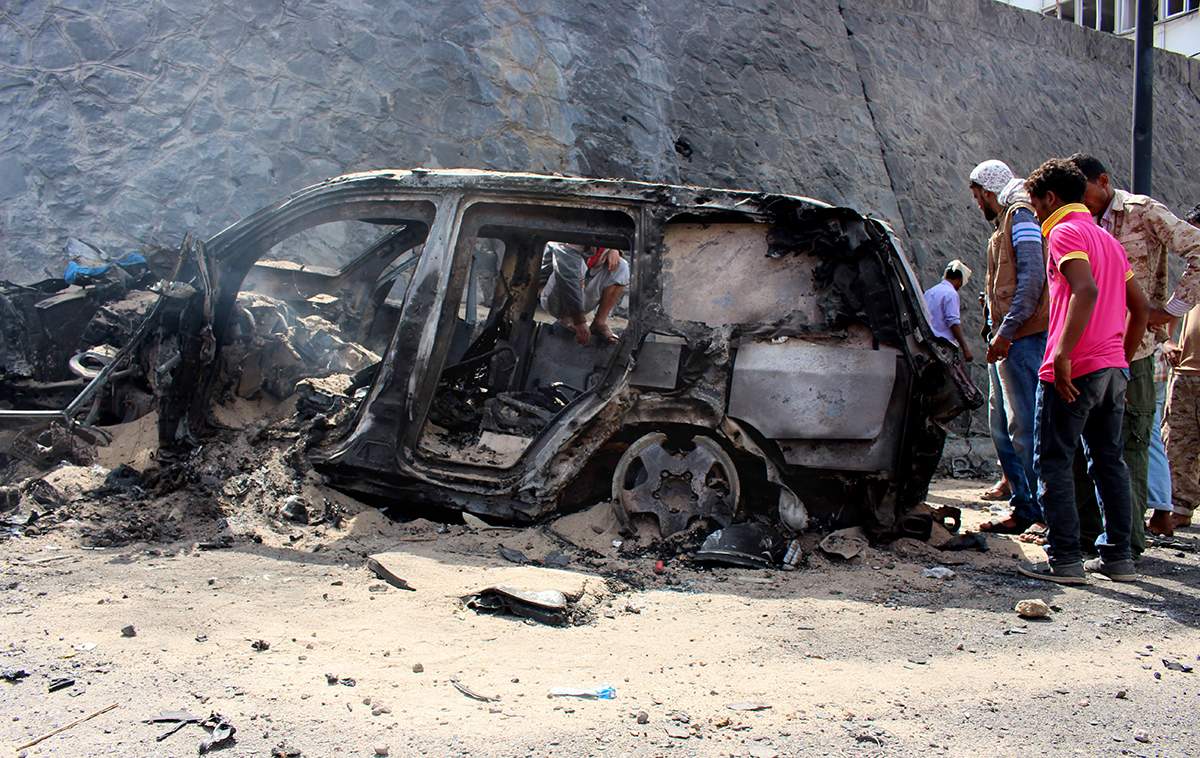 Yemenis inspect the scene of a car bomb attack that killed a Yemeni senior official in the southern port city of Aden, Yemen, Sunday, Dec. 6.