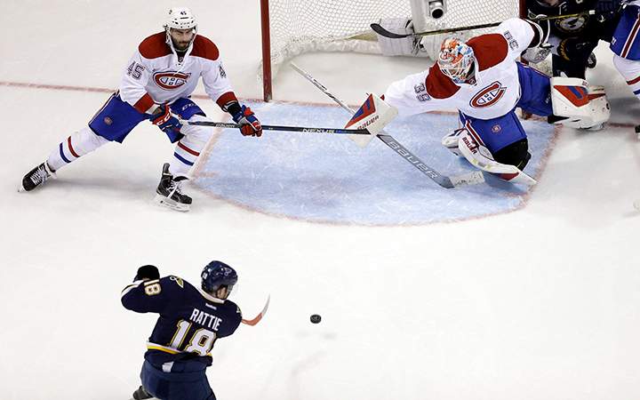 St. Louis Blues' Ty Rattie scores past Montreal Canadiens goalie Mike Condon and Mark Barberio during the third period of an NHL hockey game Saturday, Jan. 16, 2016, in St. Louis. The Blues won 4-3 in overtime.