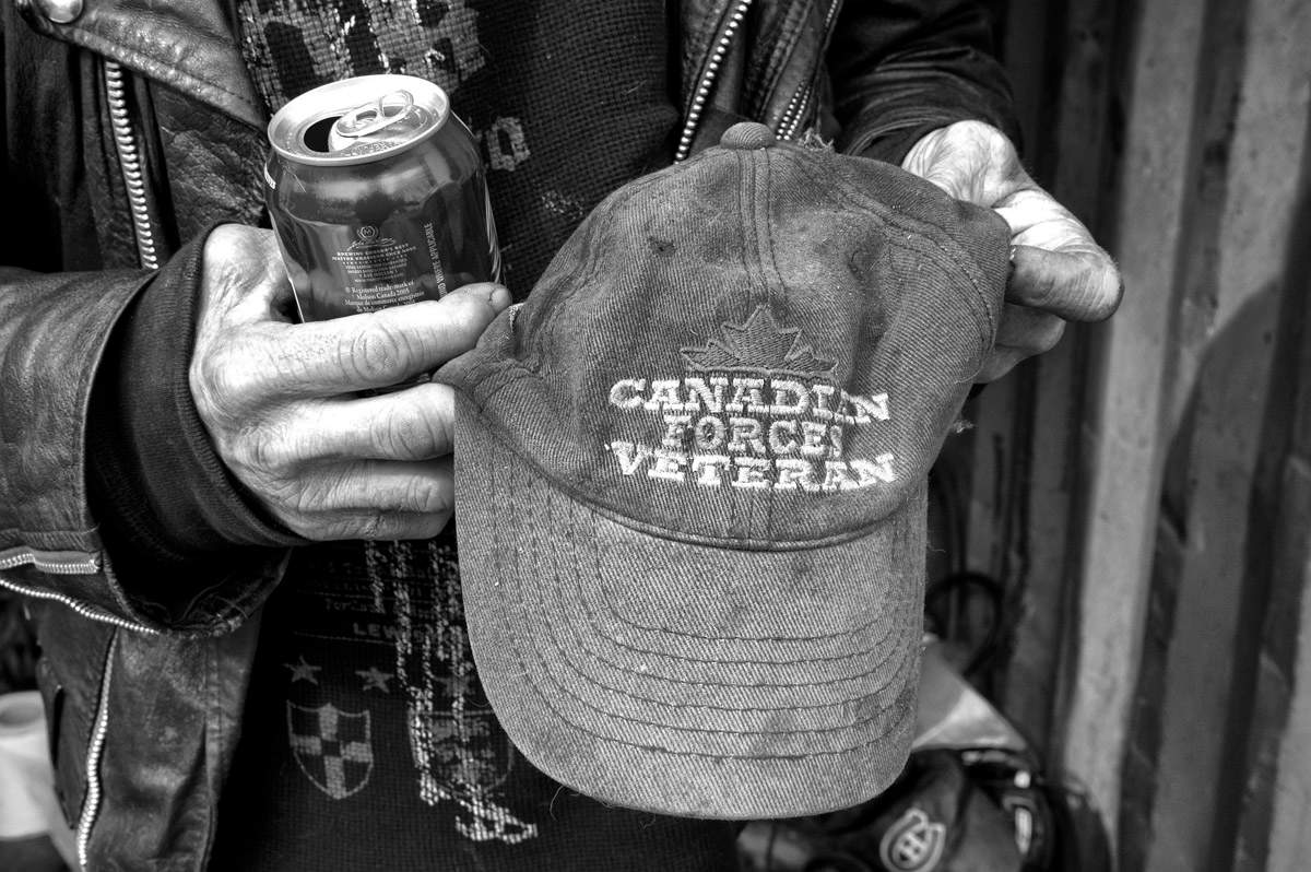 Claude Lord, a homeless veteran living in a shipping container in Montreal, shows a cap to a photographer. 