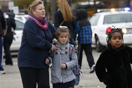 Students at Amy Beverland Elementary School are picked up after school after a bus accident in Indianapolis on Tuesday, Jan. 26, 2016. Authorities said an adult was killed and two children were seriously injured when a bus waiting outside the elementary school suddenly lurched forward and struck them.