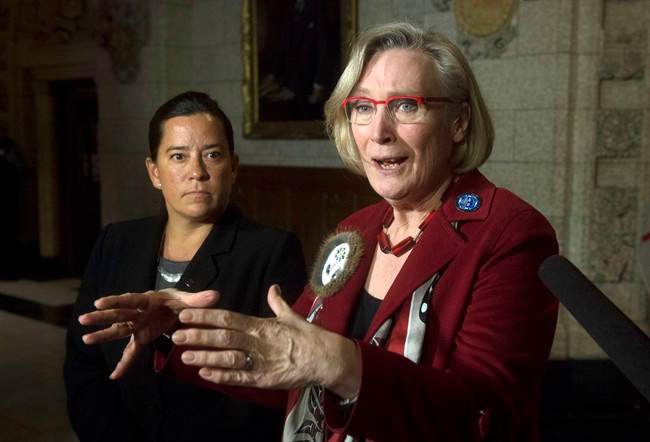 Minister of Justice and Attorney General of Canada Jody Wilson-Raybould, left, looks on as Minister of Indigenous and Northern Affairs Carolyn Bennett speaks about the Canadian Human Rights Tribunal regarding discrimination against First Nations children in care during a news conference on Parliament Hill in Ottawa, Tuesday, January 26, 2016. 