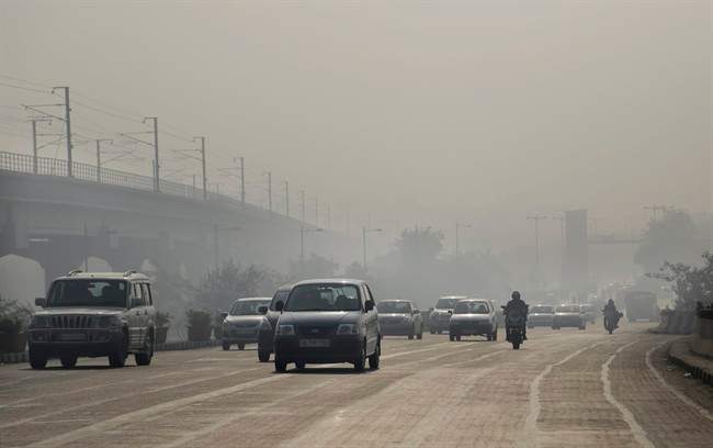 Vehicles move through morning smog on the first day of a two-week experiment to reduce the number of cars to fight pollution in New Delhi, India, Friday, Jan. 1, 2016. 