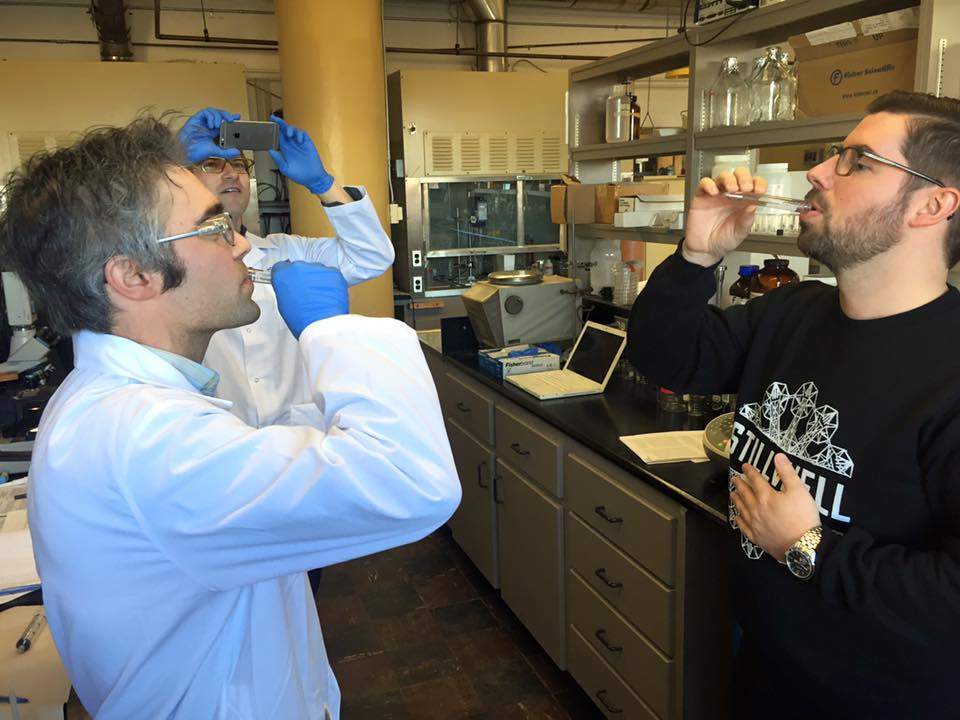 Christopher Reynolds and Dr. Andrew MacIntosh take a swig of the beer from the century-old beer bottle found in the Northwest Arm in Halifax. 