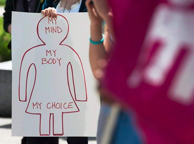 A protester holds a pro-choice sign at Victoria Park, in Halifax, during a demonstration for access to abortion services on the one-year anniversary of the death of Dr. Henry Morgentaler, May 29, 2014.