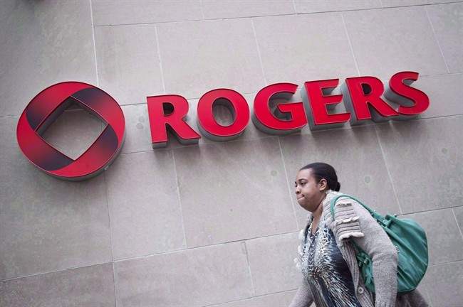 A pedestrian walks past the Rogers headquarters in Toronto. 