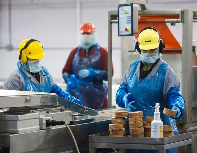 Maple Leaf Foods employees handle food products inside the company's meat facility in Toronto on Monday, December, 15, 2008. 