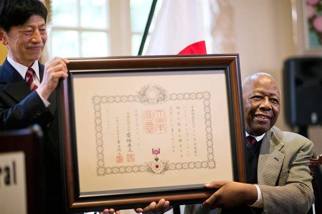 Hank Aaron, right, is presented with a framed certificate for the Order of the Rising Sun, Gold Rays with Rosette, by Takashi Shinozuka, left, Consul General of Japan in Atlanta, during a ceremony at the consul general’s home, Thursday, Jan. 14, 2016, in Atlanta. (AP Photo/David Goldman)