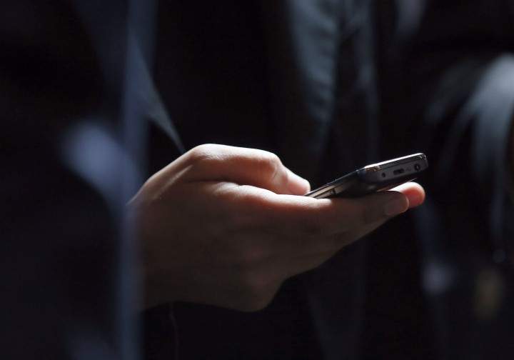 A file photo of a person holding a cell phone.