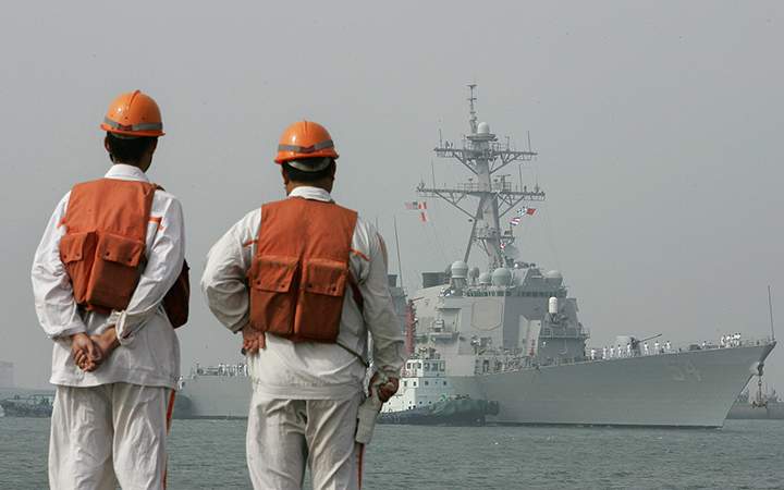 Ship tenders wait dockside for the arrival of the USS Curtis Wilbur (DDG54), a US Navy AEGIS class guided missile destroyer in Qingdao, in eastern China's Shandong province. 